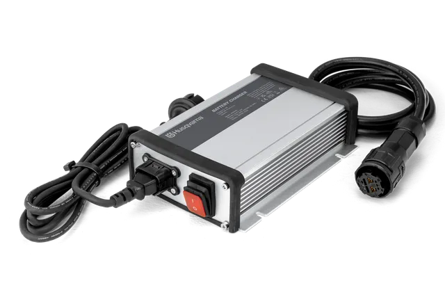 Front view of a Husqvarna battery charger with cables.