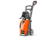 Front view of a Husqvarna pressure washer with hose reel and wheels.