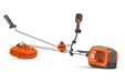 Side view of a Husqvarna brush cutter with ergonomic handle and visible battery compartment.