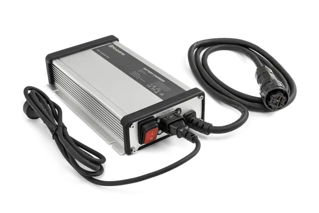 Front view of a Husqvarna battery charger with attached cables.